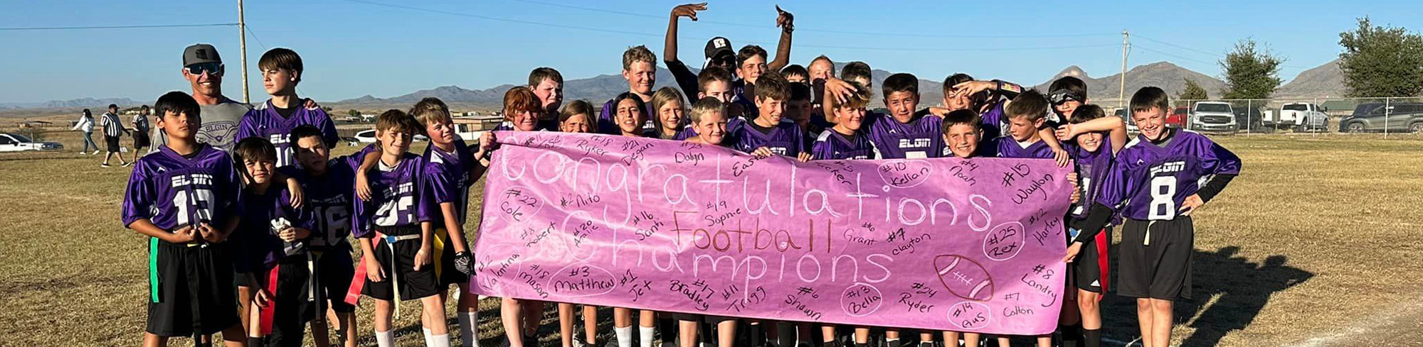 Sonoita football team posing together behind sign the reads congratulations football champions