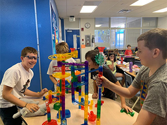 students playing with a marble track