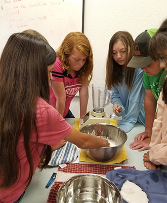 students stirring a metal bowl