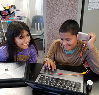 Two middle school girls working on a project outside