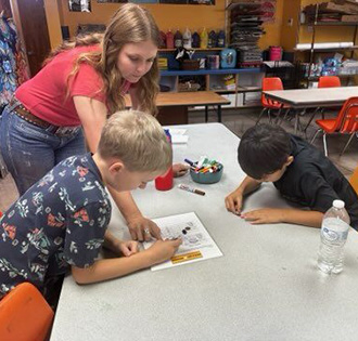 Three happy elementary students making a heart shape with cubes