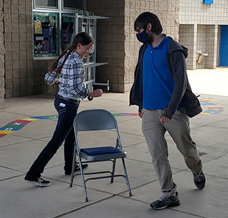 Two students playing musical chairs